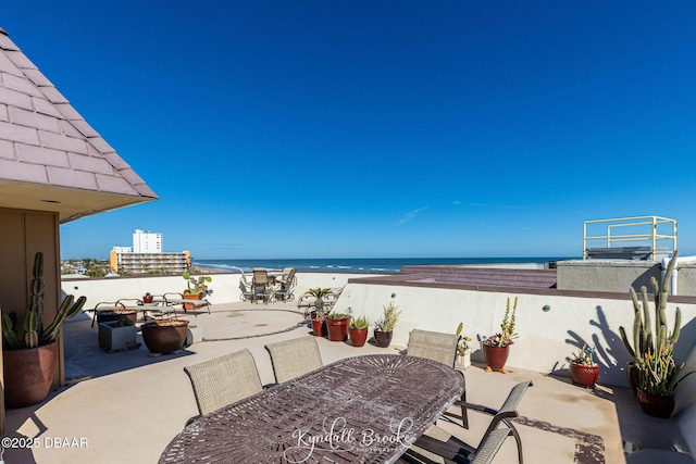 view of patio / terrace with a water view and a view of the beach