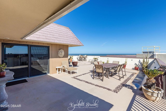 view of patio featuring a water view and a beach view