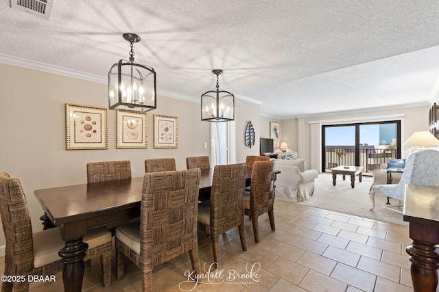 tiled dining space featuring ornamental molding and a textured ceiling