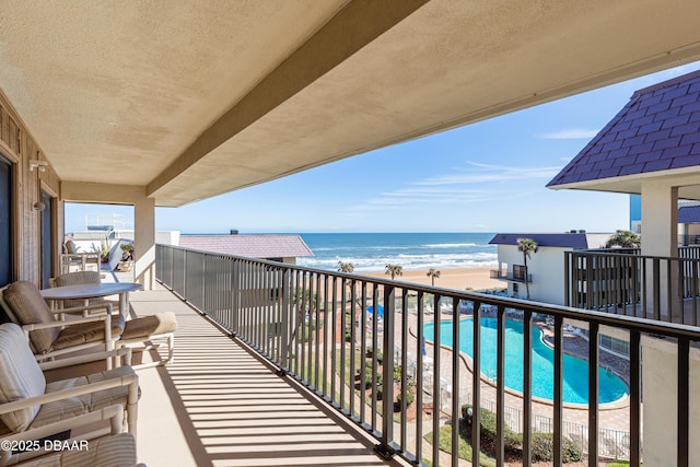 balcony featuring a water view and a beach view