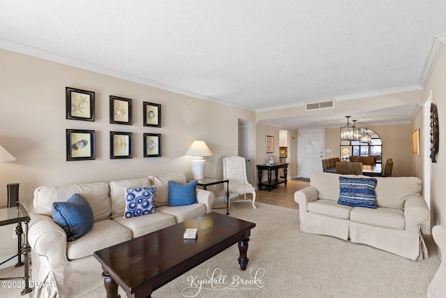 living room with crown molding, a textured ceiling, and a notable chandelier