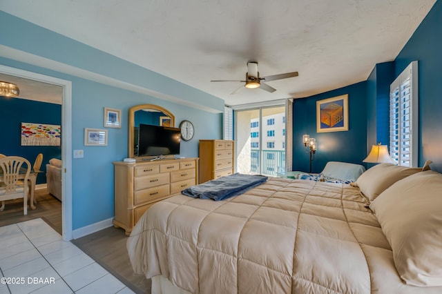 bedroom featuring ceiling fan, a wall of windows, access to exterior, and light wood-type flooring