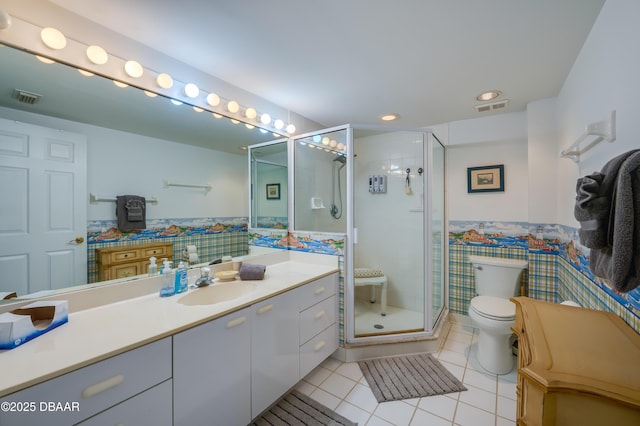 bathroom with tile patterned flooring, tile walls, vanity, an enclosed shower, and toilet