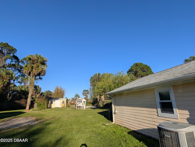 view of yard featuring an outdoor structure and central AC