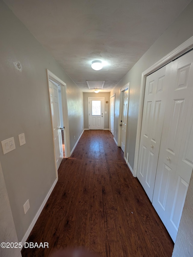 hall with baseboards and dark wood-style flooring