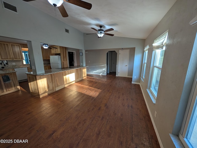 kitchen featuring visible vents, dark wood finished floors, lofted ceiling, white appliances, and a ceiling fan