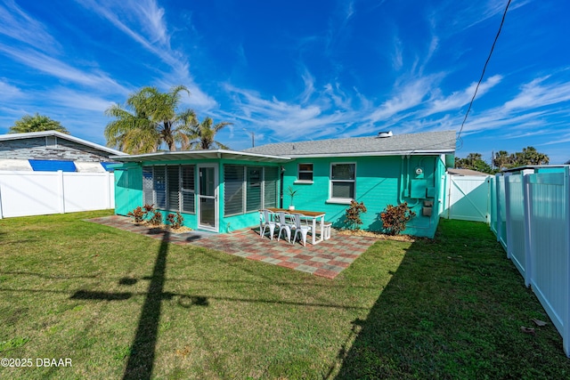 back of house with a yard, a patio area, and a sunroom