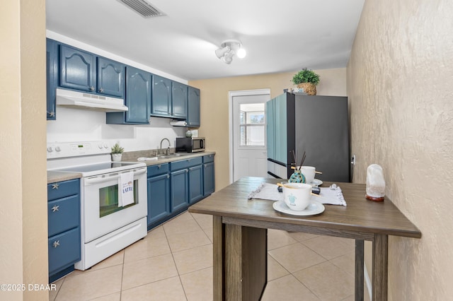 kitchen featuring appliances with stainless steel finishes, blue cabinetry, light tile patterned floors, and sink