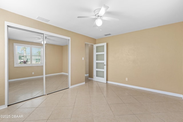 unfurnished bedroom featuring a closet, ceiling fan, and light tile patterned flooring