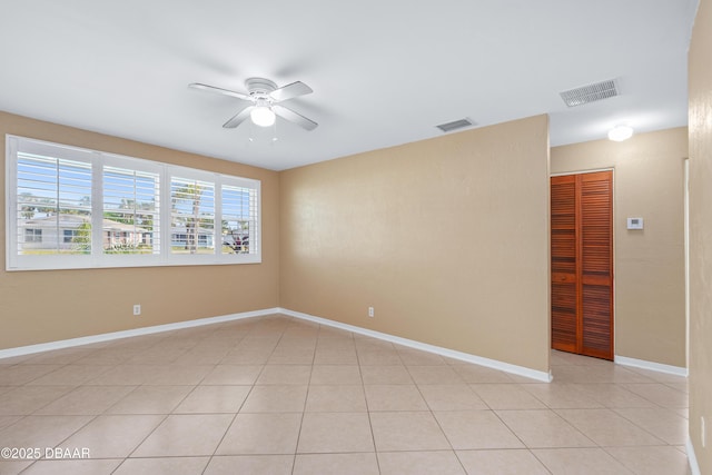 tiled empty room with ceiling fan