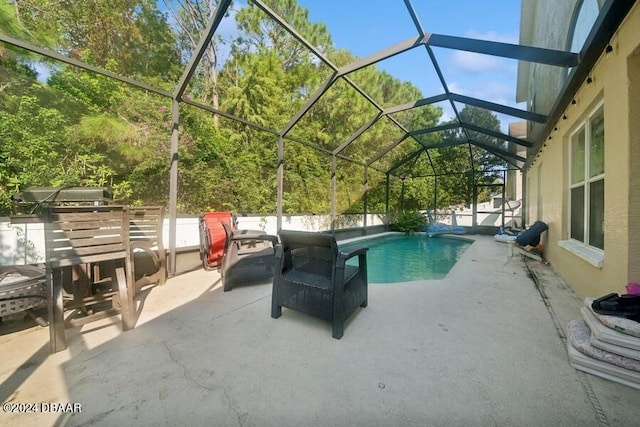 view of swimming pool with a lanai and a patio area