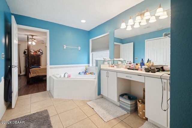 bathroom with tile patterned floors, vanity, tiled tub, and ceiling fan