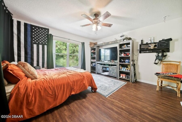 bedroom with a textured ceiling, dark wood-type flooring, and ceiling fan