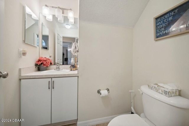 bathroom featuring hardwood / wood-style flooring, vanity, toilet, and lofted ceiling