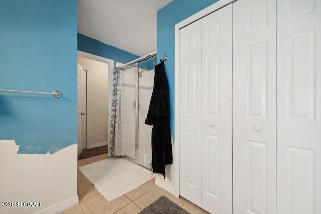 bathroom with walk in shower and tile patterned floors