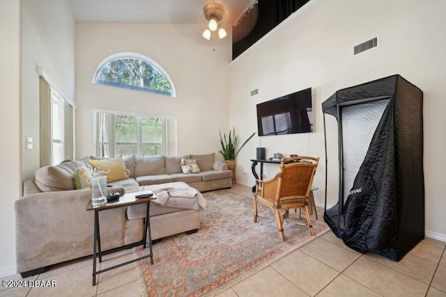 living room featuring ceiling fan, light tile patterned floors, and high vaulted ceiling