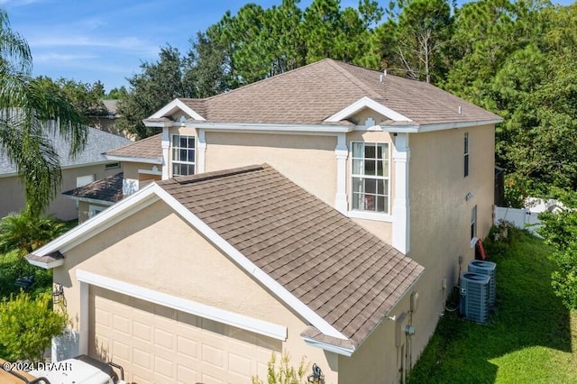 view of front of house with central air condition unit and a garage