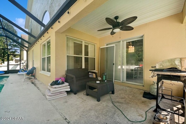 view of patio / terrace featuring ceiling fan and glass enclosure