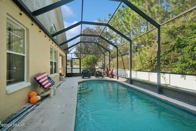 view of pool featuring glass enclosure and a patio area