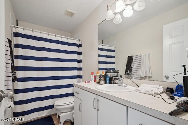 bathroom with toilet, vanity, and a textured ceiling