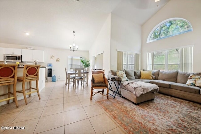 tiled living room featuring high vaulted ceiling and a notable chandelier