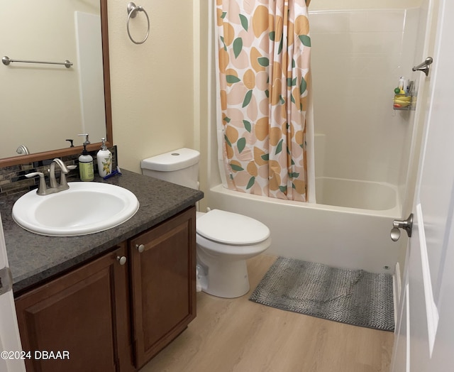 full bathroom featuring hardwood / wood-style floors, vanity, toilet, and shower / bathtub combination with curtain