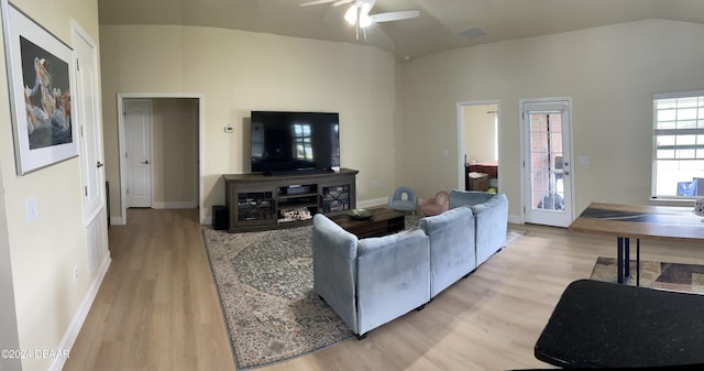 living room featuring light hardwood / wood-style floors, ceiling fan, and lofted ceiling