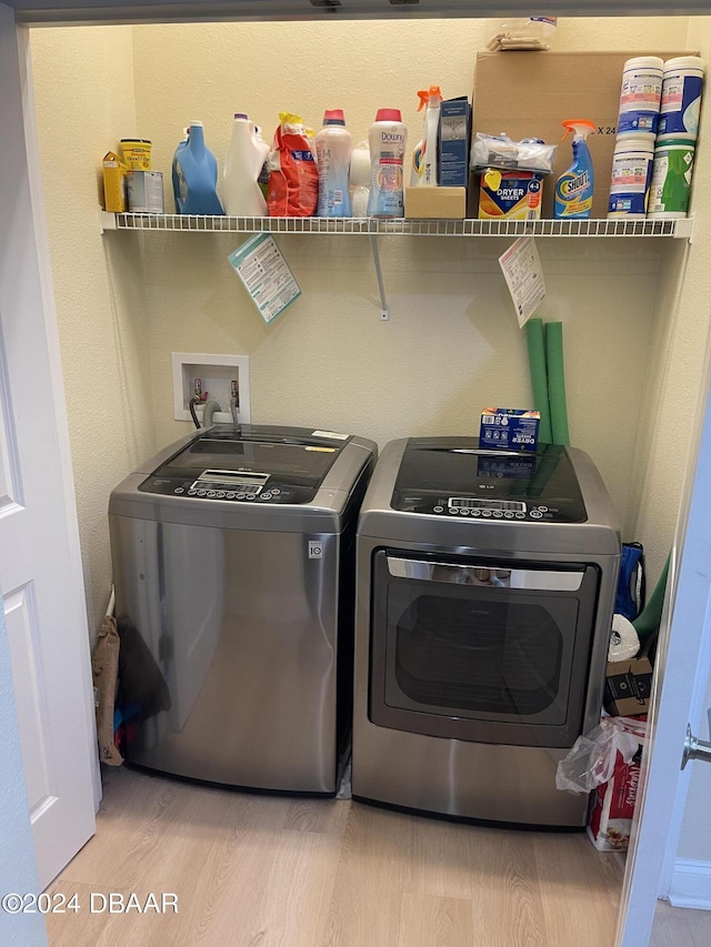 laundry area featuring washer and dryer and light wood-type flooring