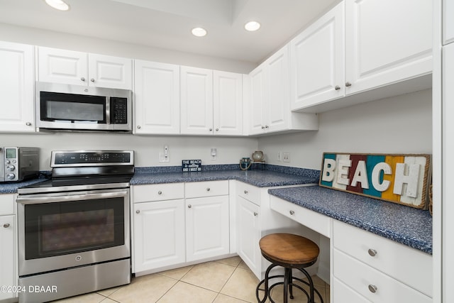 kitchen featuring white cabinets, light tile patterned floors, and stainless steel appliances