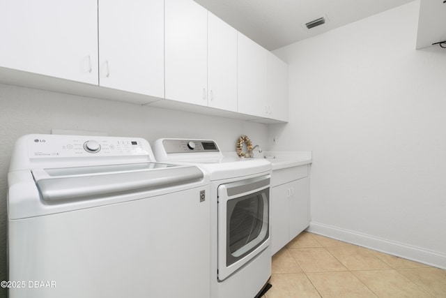 washroom with visible vents, cabinet space, separate washer and dryer, light tile patterned flooring, and baseboards