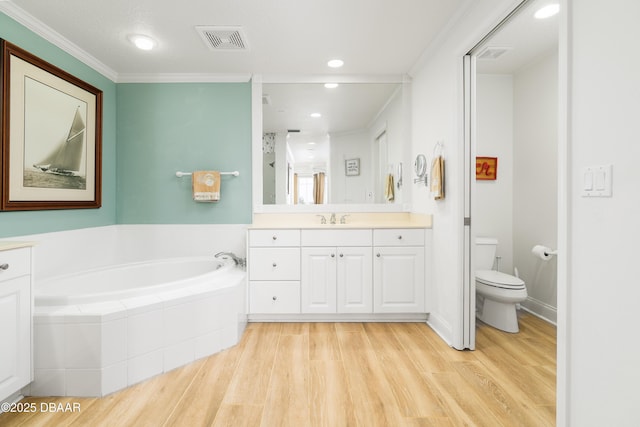 bathroom featuring visible vents, wood finished floors, crown molding, a bath, and vanity