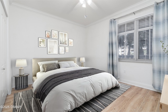 bedroom with light wood-style flooring, ceiling fan, baseboards, and ornamental molding