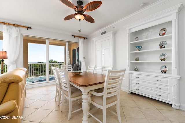 tiled dining area featuring a textured ceiling, ceiling fan, and crown molding