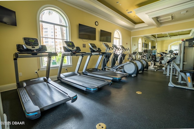 workout area featuring a tray ceiling, visible vents, baseboards, and ornamental molding