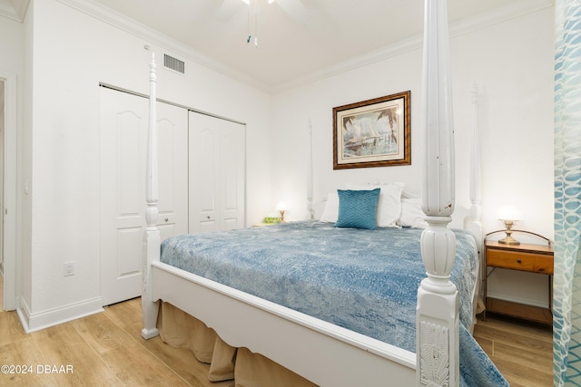 bedroom with a closet, ceiling fan, hardwood / wood-style floors, and ornamental molding