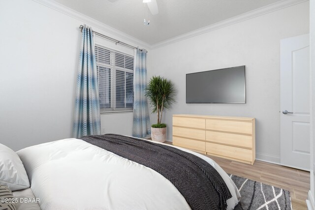 bedroom with wood finished floors, a ceiling fan, baseboards, and ornamental molding