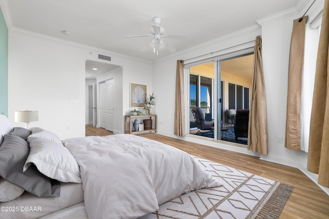 bedroom featuring access to exterior, wood finished floors, visible vents, and ornamental molding