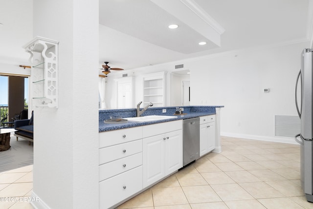 kitchen with dark countertops, light tile patterned flooring, stainless steel appliances, white cabinets, and crown molding