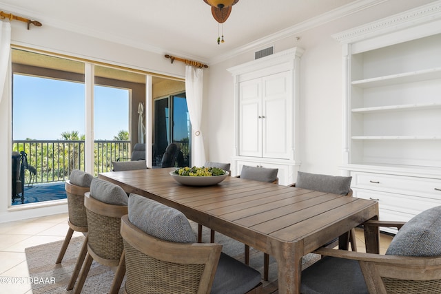 dining room featuring light tile patterned floors, visible vents, crown molding, and built in features