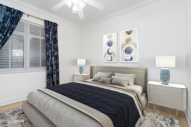 bedroom featuring baseboards, wood finished floors, ornamental molding, and a ceiling fan