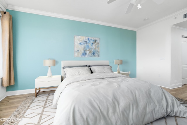 bedroom featuring crown molding, baseboards, and wood finished floors