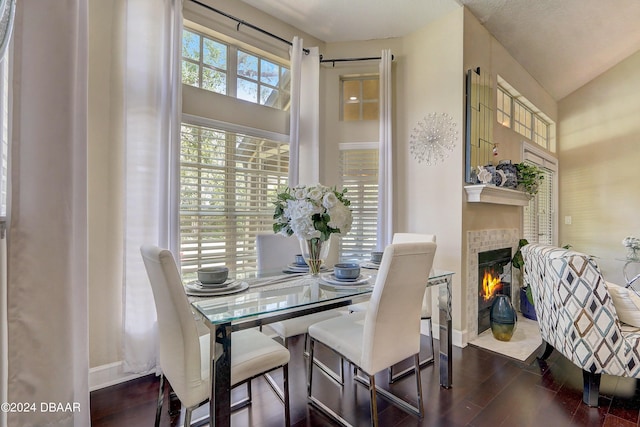 dining room with baseboards, wood finished floors, and a tile fireplace