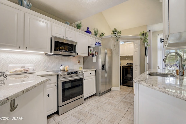 kitchen featuring a sink, lofted ceiling, appliances with stainless steel finishes, and white cabinets