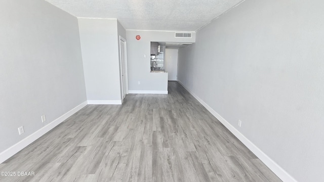 219 S Atlantic Ave Unit 120, Daytona Beach, FL 32118 - spare room with visible vents, a textured ceiling, baseboards, and wood finished floors