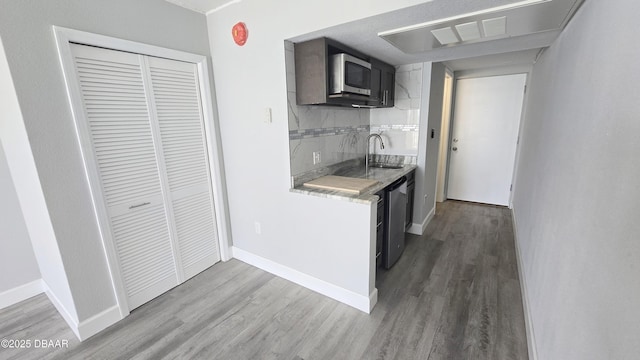 219 S Atlantic Ave Unit 120, Daytona Beach, FL 32118 - kitchen with light wood-type flooring, a sink, backsplash, and stainless steel appliances