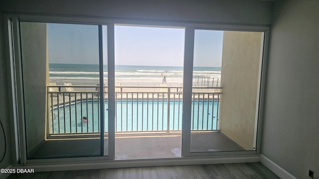 219 S Atlantic Ave Unit 120, Daytona Beach, FL 32118 - entryway featuring wood finished floors, a beach view, baseboards, and a water view