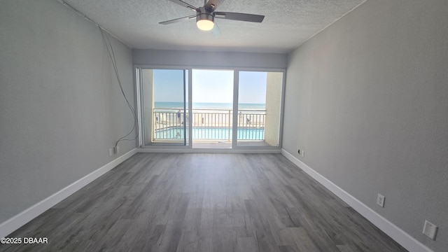 219 S Atlantic Ave Unit 120, Daytona Beach, FL 32118 - spare room featuring dark wood-type flooring, a textured ceiling, baseboards, and a ceiling fan