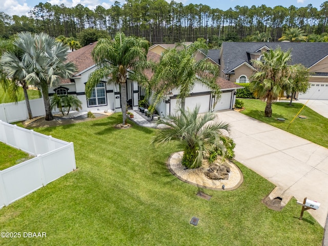 26 Ethel Ln, Palm Coast, FL 32164 - view of front facade featuring an attached garage, stucco siding, concrete driveway, a front lawn, and a fenced backyard