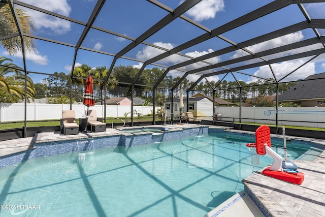 view of swimming pool with a lanai, an in ground hot tub, a patio, and a shed