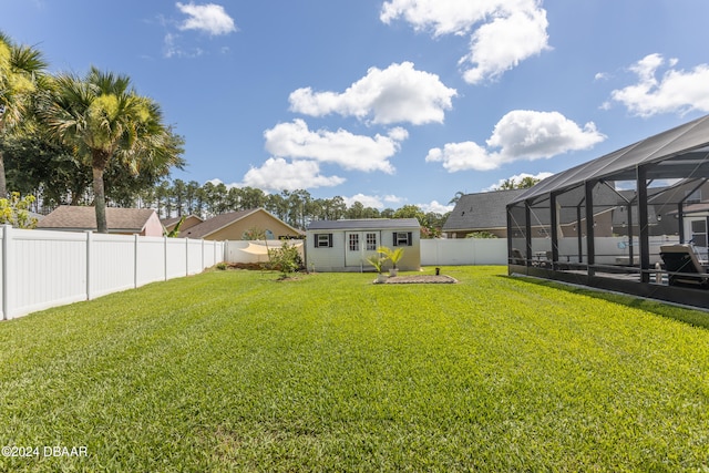 view of yard with glass enclosure and an outdoor structure